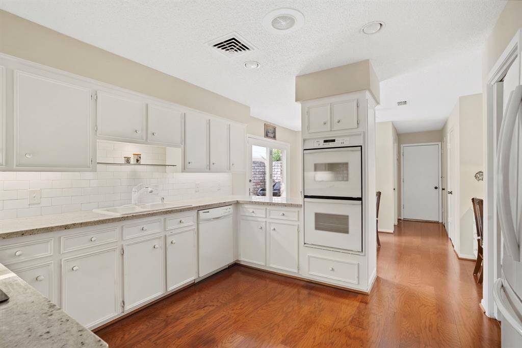 Double wall ovens complete this well-appointed space designed for both everyday living and entertaining.