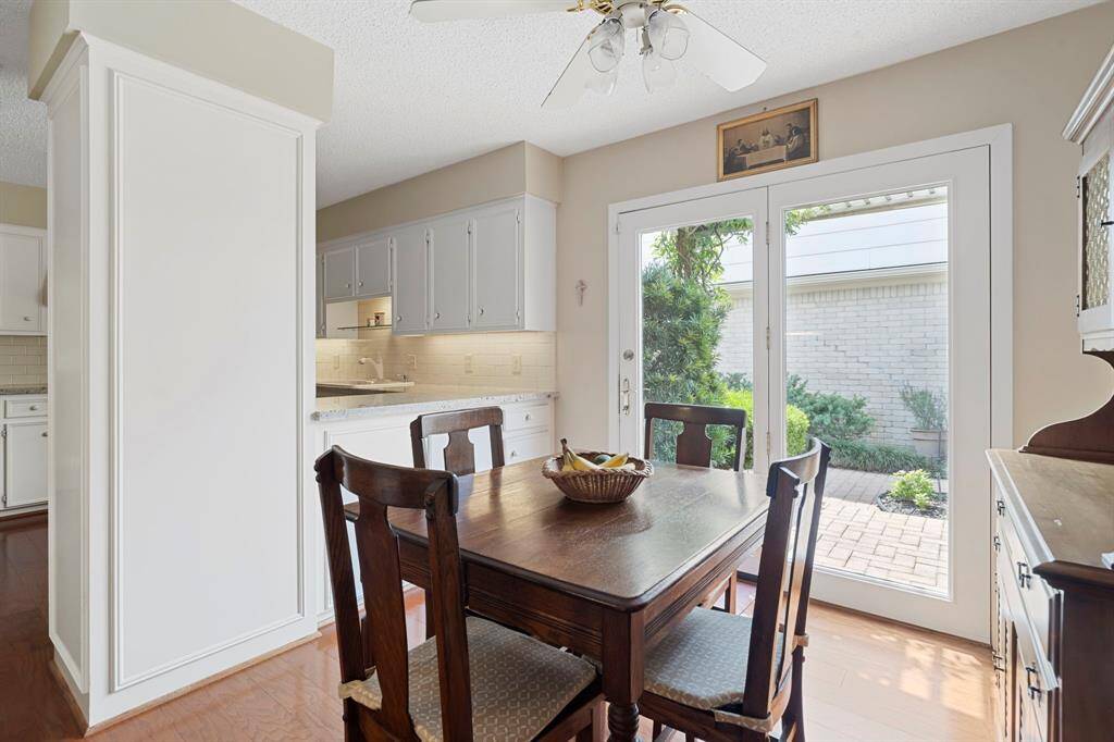 This inviting breakfast area is filled with natural light, featuring a glass door paired with a full-sized window that offers easy access to the patio or garden.