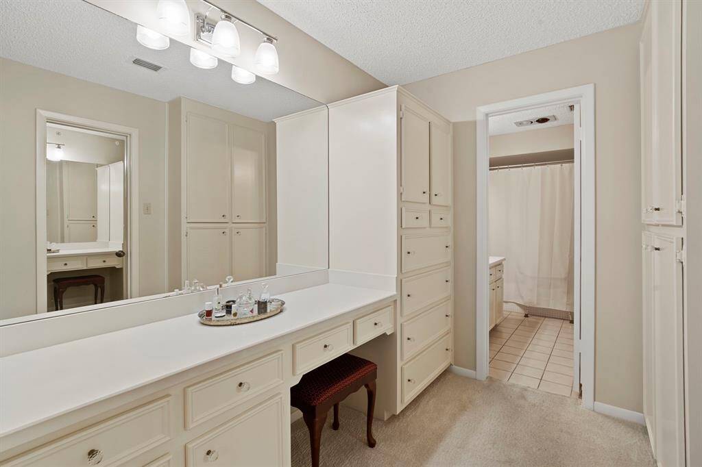 The primary bathroom offers an abundance of storage, with two spacious vanities, a dedicated make-up area, and a convenient shower/tub combo, ensuring both functionality and style.