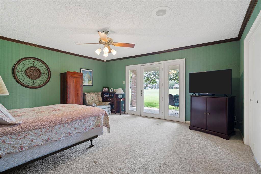 This inviting secondary bedroom boasts a glass door with sidelights, offering direct access to the back patio and sweeping views of the lush golf course beyond.