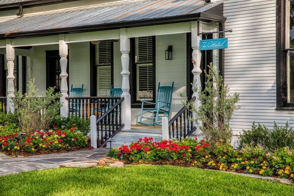 Charming blue rockers invite you to slow down on this quintessential Southern porch. Known as The Cottontail, this inviting 2-bedroom, 2-bathroom cottage is surrounded by blooming garden beds & defined by the timeless lines of its historic architecture.