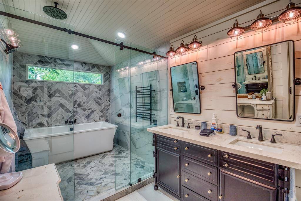 From dual vanities to designer lighting and vintage-inspired mirrors, every detail in this primary bathroom was selected for both elegance and ease.