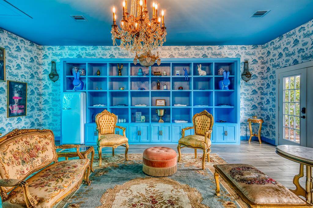 This whimsical lounge balances opulent textures with playful artistry and glowing neon flair—sure to set the tone for any gathering with its unforgettable charm.