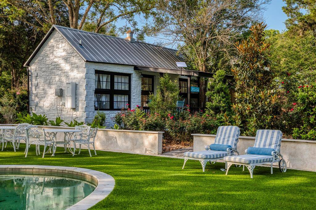 The private 3 Carat Suite guest cottage overlooks the pool and lush landscaping, offering a tranquil escape complete with alfresco lounging and garden views.