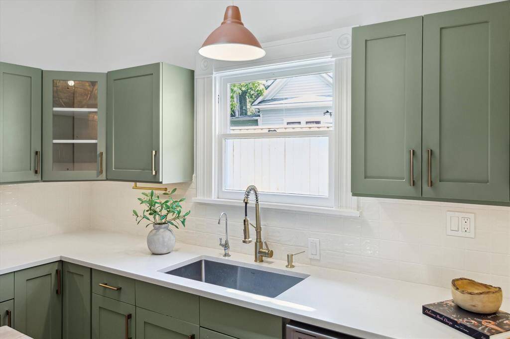 Close up of pendant light and kitchen sink overlooking side yard