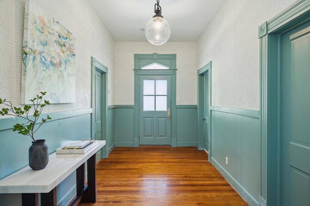 Immediately welcomed by large entry. 10 foot ceilings throughout the original part of the home. Pottery Barn pendant light, Schumacher wallpaper and wainscoting. Two bedrooms off the front right and left doors.