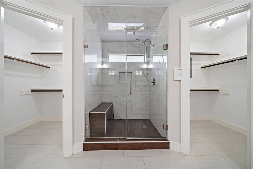 Primary bathroom with his/hers walk-in closets.