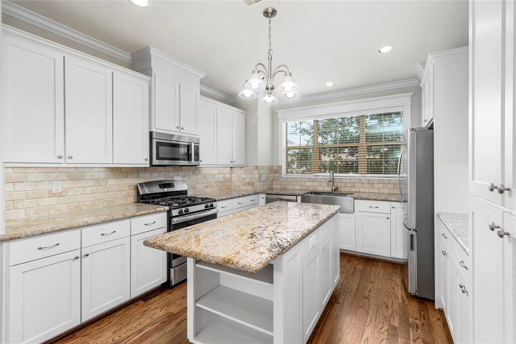 Spacious kitchen offers abundant counter space and a large central island. Generous cabinet and drawer storage. Sleek white soft-closing cabinetry.