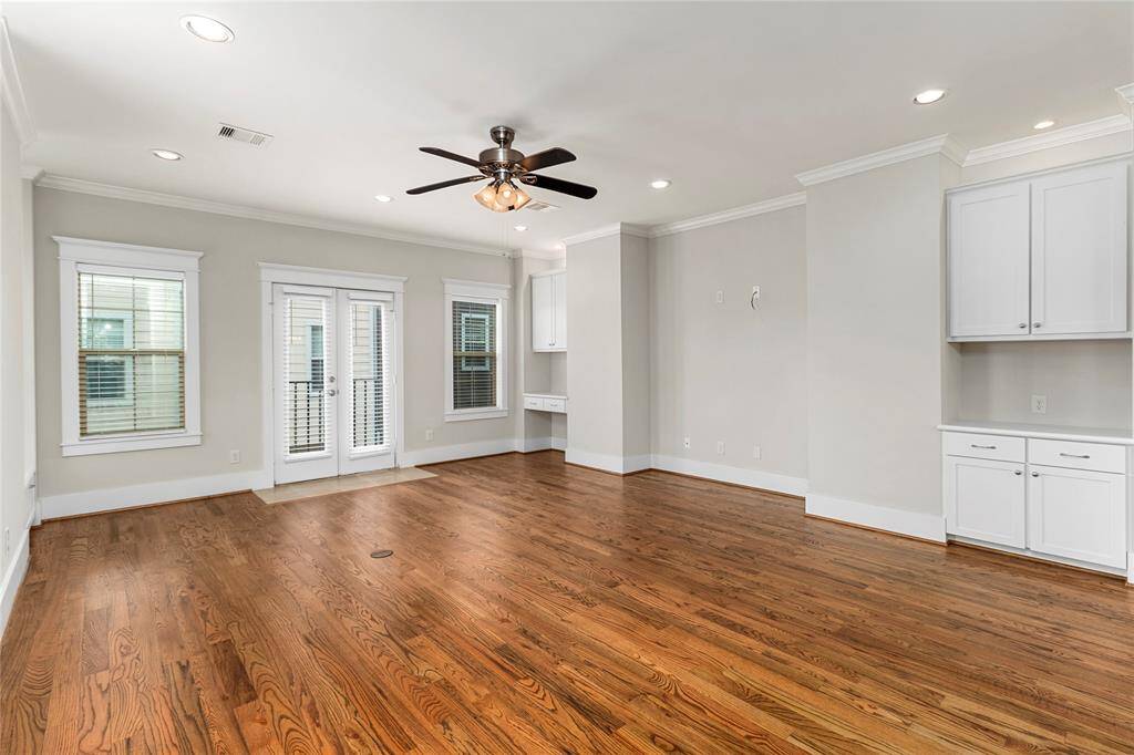 Living Room includes recessed TV nook for streamlined media setup. Built-in desk with cabinets and drawers provides a convenient workspace.