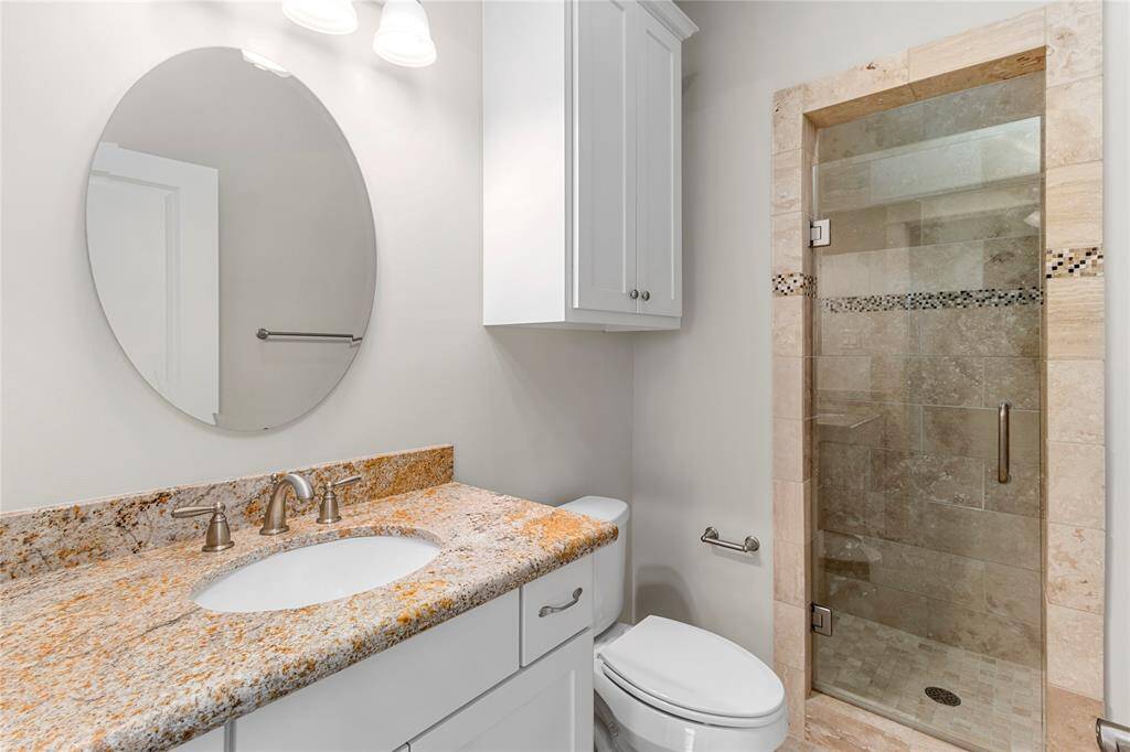 3rd Floor Bedroom-En-Suite Bathroom. Granite-topped vanity. Crisp white cabinetry creates a clean modern aesthetic. Spa-inspired shower enclosed by frameless glass door.