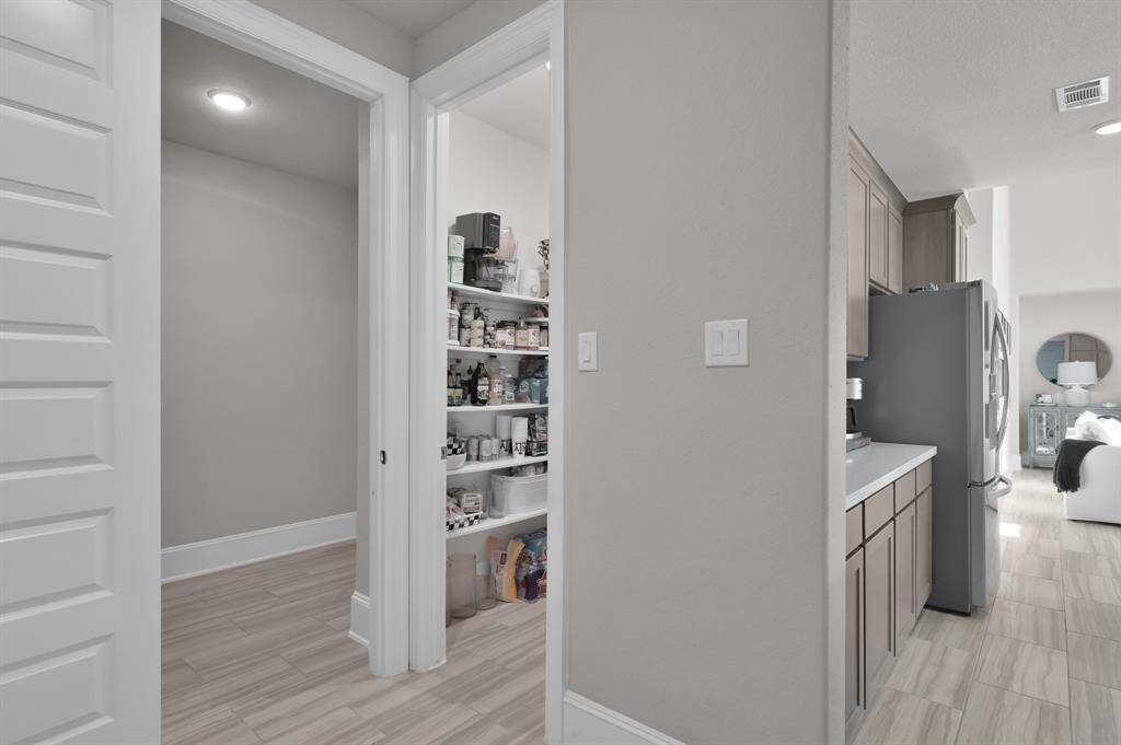Large pantry conveniently located next to the oversized utility room.  The utility room offers additional space and an outlet perfect for a secondary fridge.
