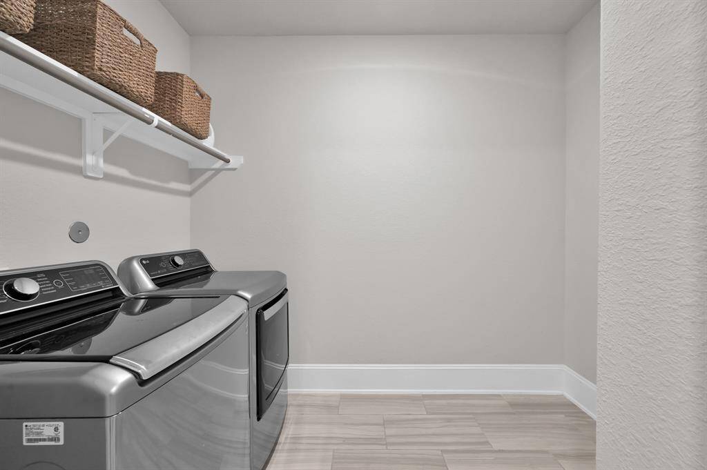 The utility room offers additional space and an outlet perfect for a secondary fridge.