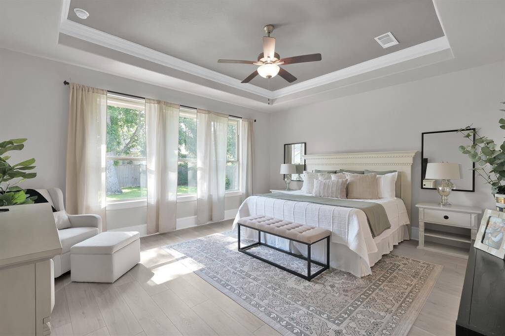 Over-sized bedroom with recessed ceilings and pool views.