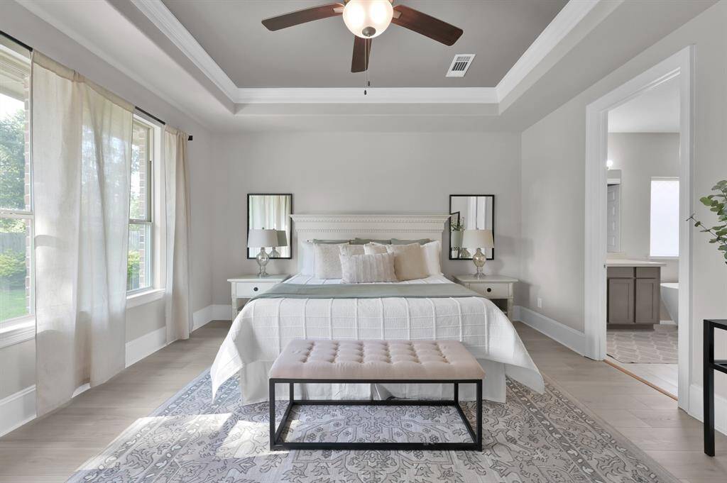 Over-sized bedroom with recessed ceilings and pool views.