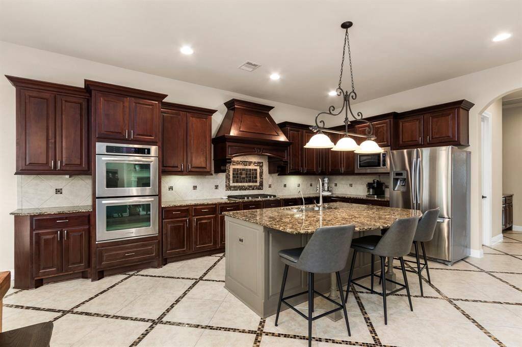 This wonderful kitchen boasts stainless steel appliances including Kitchen Aid refrigerator (stays with the house), Kitchen Aid double ovens, a built-in microwave and Bosch dishwasher.