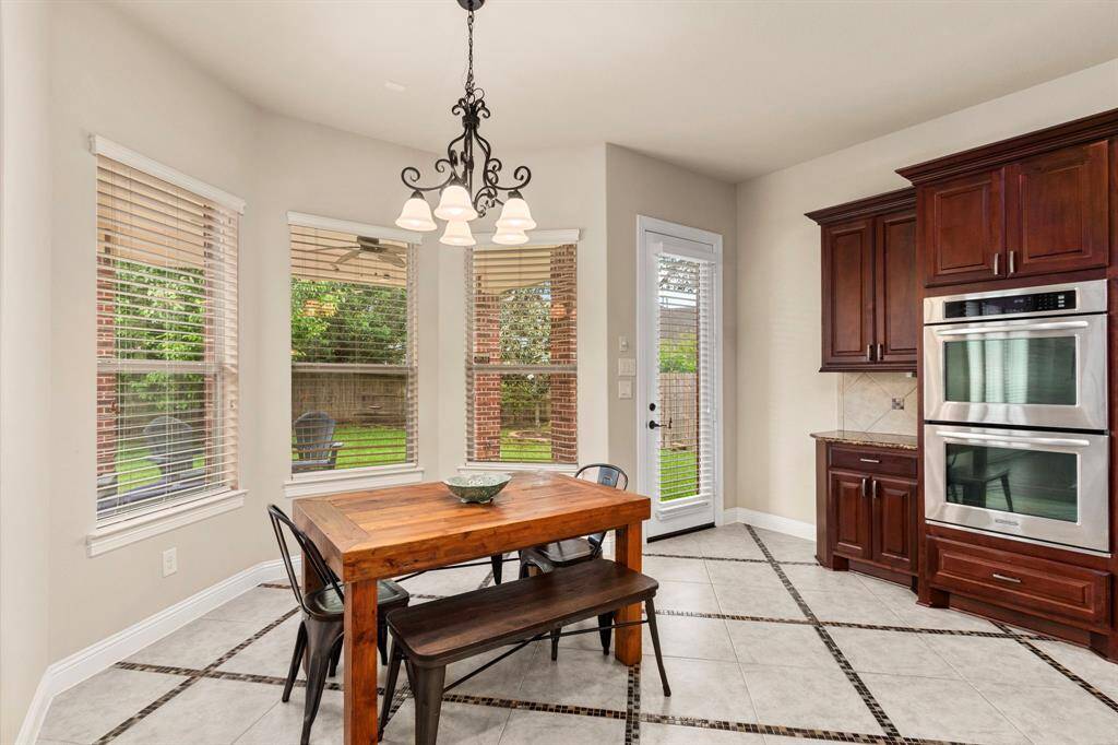 The breakfast area boasts another designer light fixture that coordinates with the fixture that sits above the center island in the kitchen. The light and bright space is large with plenty of room for a large table and seating. A wonderful spot for casual dining and family meals.