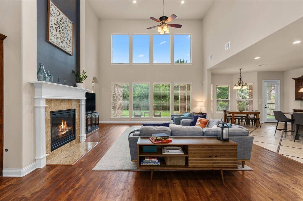 The soaring ceilings and floor-to-ceiling windows create an airy, expansive atmosphere with beautiful views of the backyard.