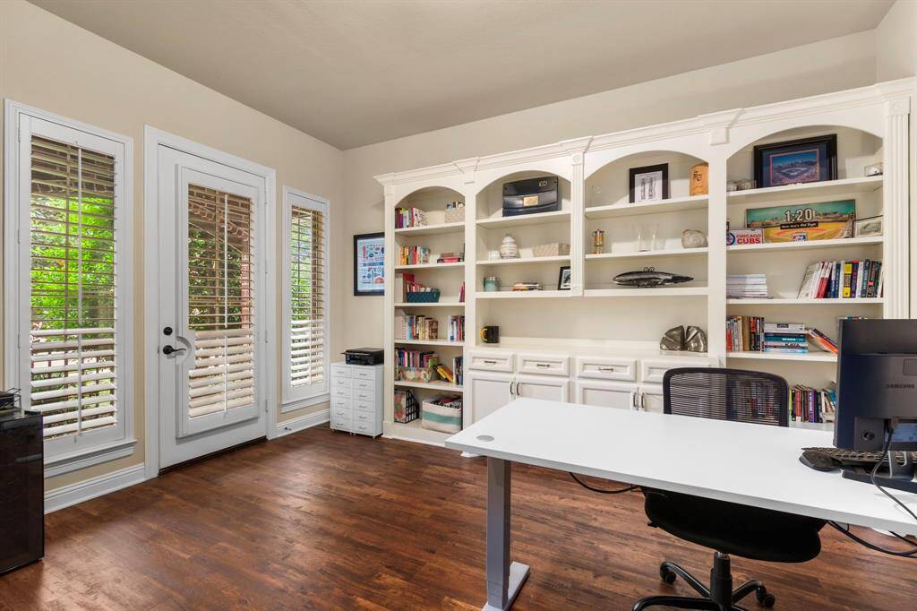 The plantation shuttered windows sit on both sides of a door that opens to a private patio area.
