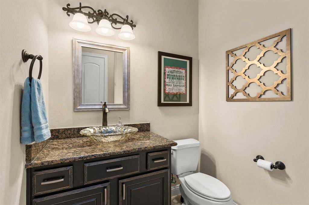This pretty half bath with granite topped cabinet and glass basin sink is lconveniently located off of the front entry and close to the main living areas of this home.