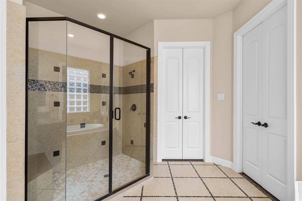 The large, glass enclosed shower offers plenty of room and provides  a built-in bench.