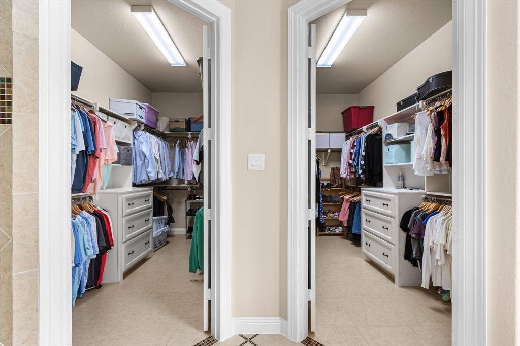The ensuite bath boasts not one, but two separate walk-in closets with custom builit-ins. There is plenty of space for hanging clothes and storage with both drawers and shelves.
