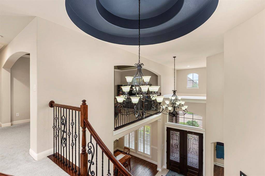 A look down at the stunning entry from the second floor. Notice the gorgeous ceiling details with double designer chandeliers.