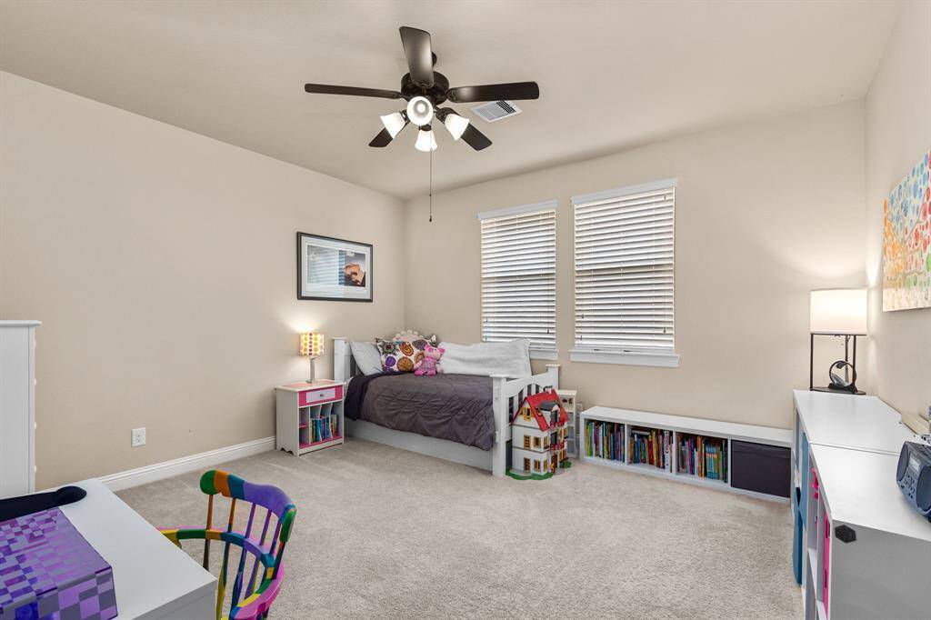 Spacious secondary bedroom with neutral, plush carpet, ceiling fan, nice-sized closet and bathroom.