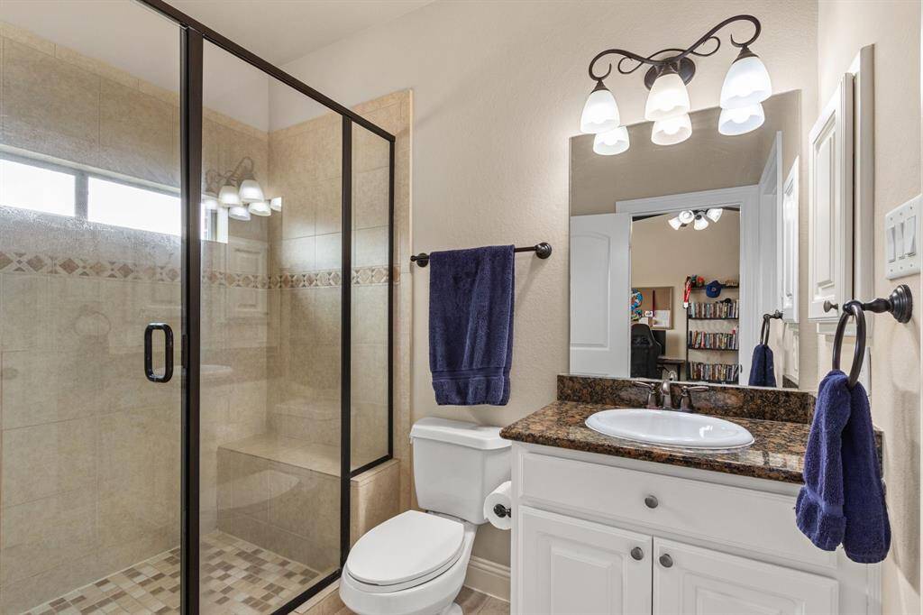 This bedroom's private bath offers a large glass enclosed shower with bench.