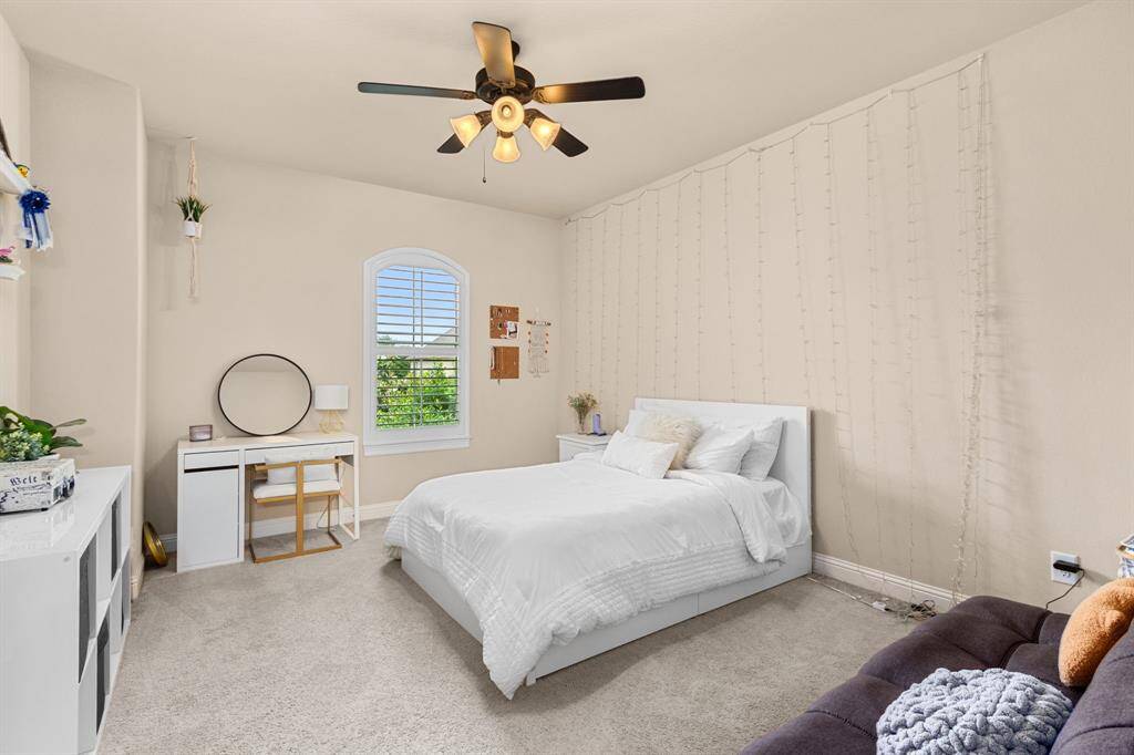 Spacious bedroom with neutral carpet, ceiling fan, nice-sized closet and a private, attached bath.