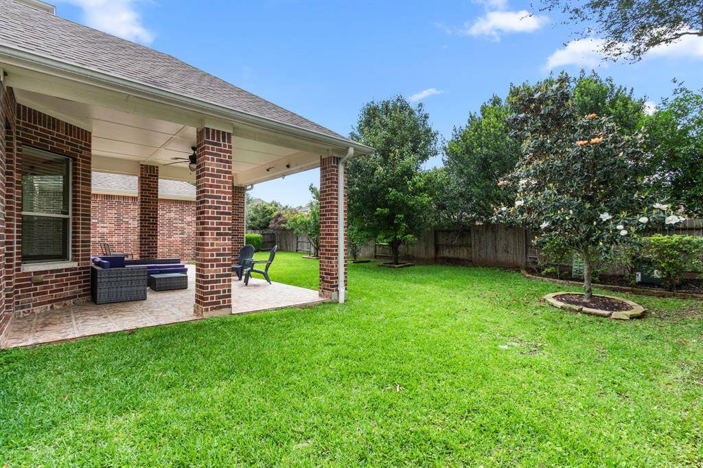 A view of the patio and large greenspace that surrounds this great home.