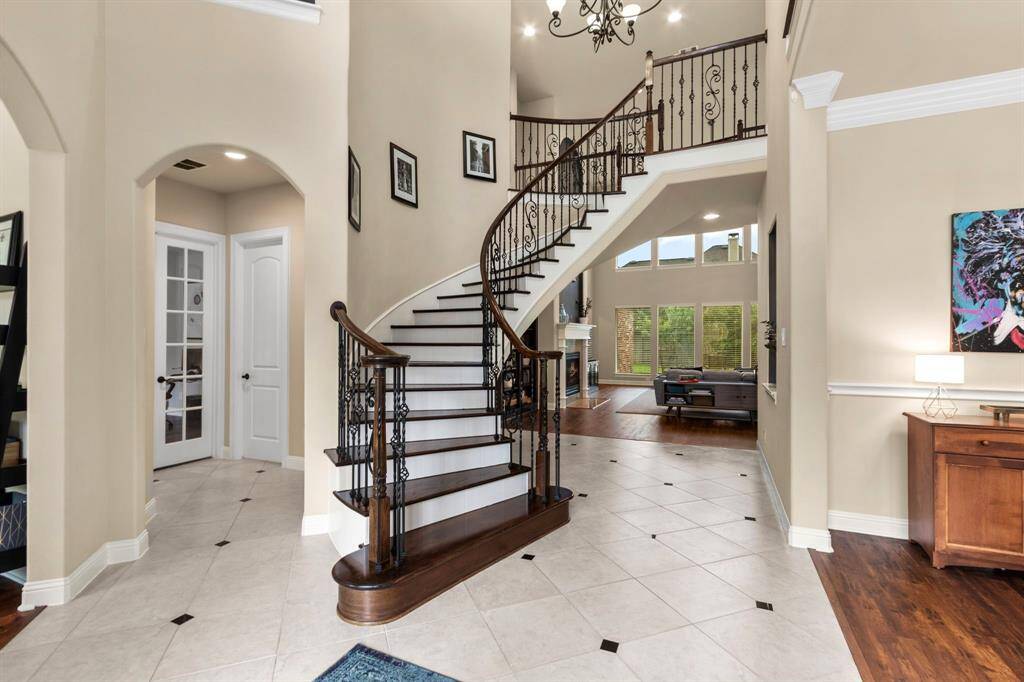 This photo from the front entry shows the formal dining room on the right, the family room past the stairway and to the left a peek in to the sitting room and into a hallway that leads to the private study and powder bath.