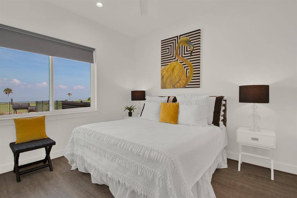 Bright, modern bedroom featuring a large window with a scenic view of the pool and a connecting jack-and-jill bath.