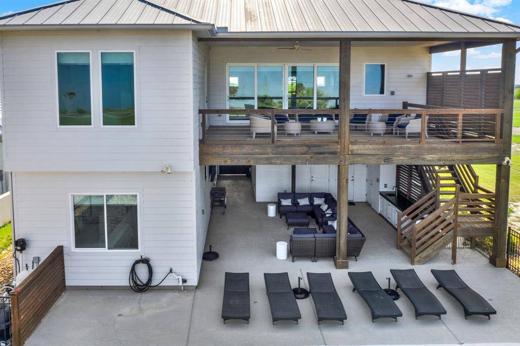 The covered spaces offer plenty of protection from the elements on the spacious covered upper deck and a lower patio area, ideal for outdoor relaxation and entertaining. Access to the upper level is provided by a set of wooden stairs.