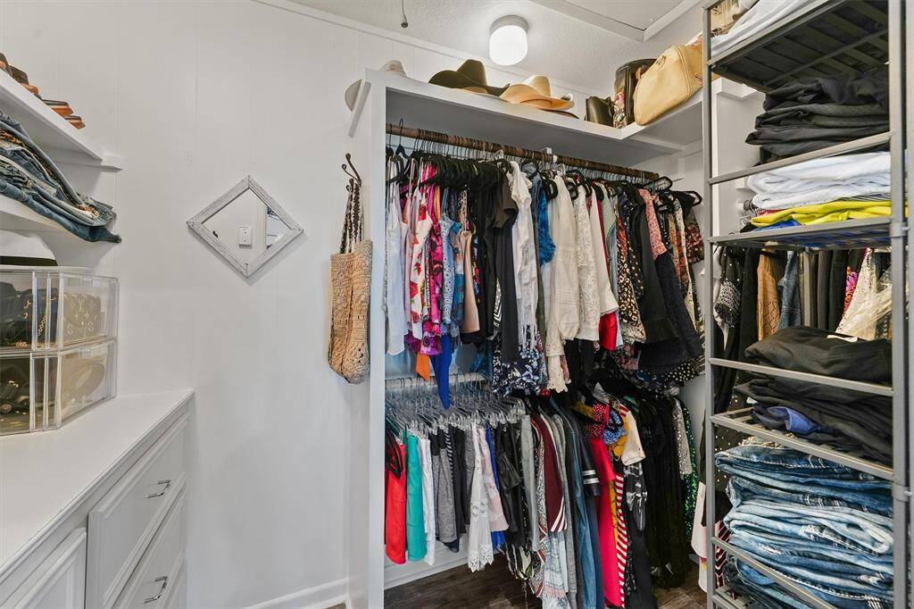 This photo showcases a spacious, organized walk-in closet with ample hanging space, shelving for clothes, and storage for accessories, offering a functional and stylish storage solution.