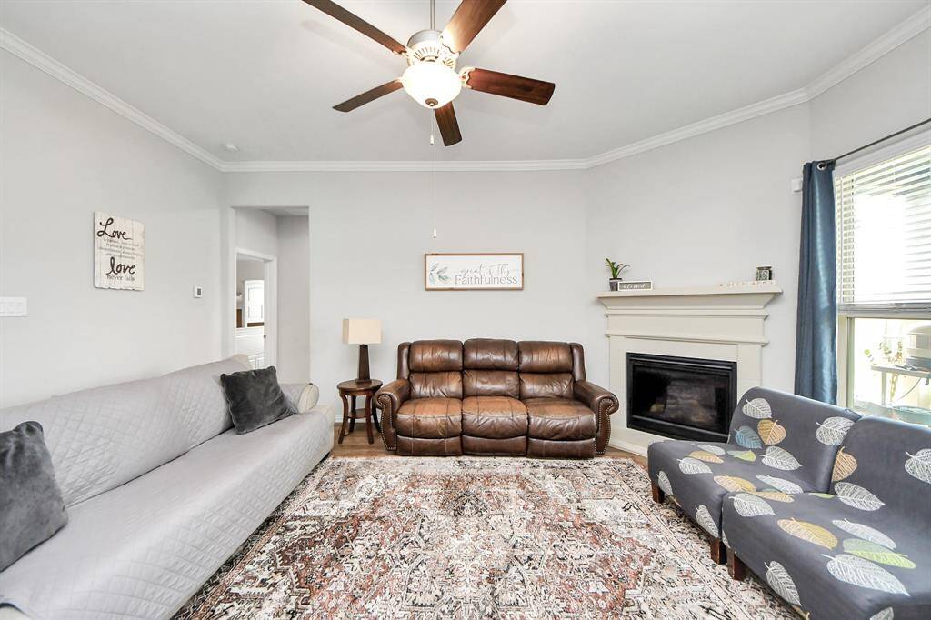 Enjoy conversations in the living room which includes high ceilings, ceiling fan, and a fireplace!
