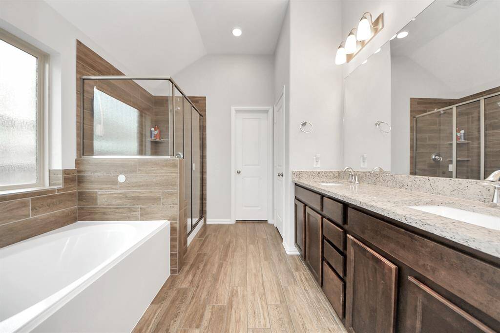 The secondary bathroom has dual sinks, soaker tub and expanded shower.
