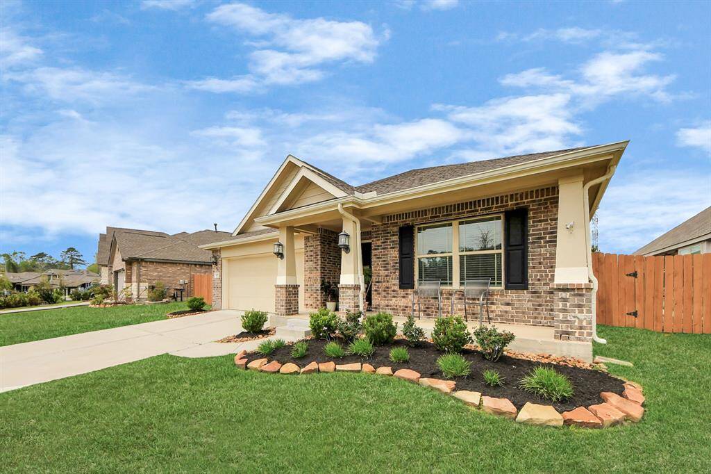 The exterior of the home features 4 sides brick, covered front porch, gutters all around, security system, A/C unit (2023), extended back patio, and exterior natural gas line.