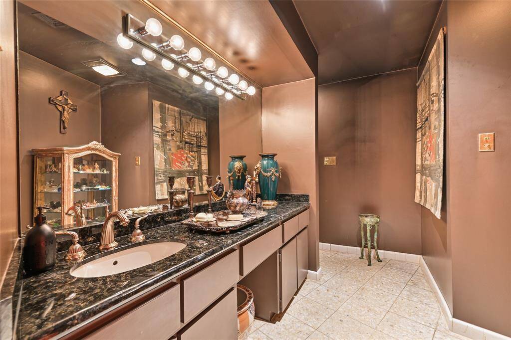This chic bathroom boasts dramatic lighting, a granite vanity, and luxe finishes—perfect for guests.