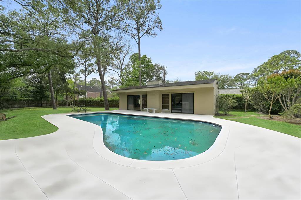 Step into your own private retreat—this expansive backyard features a sparkling pool, lush mature trees, and ample space for outdoor entertaining or relaxing in the shade.