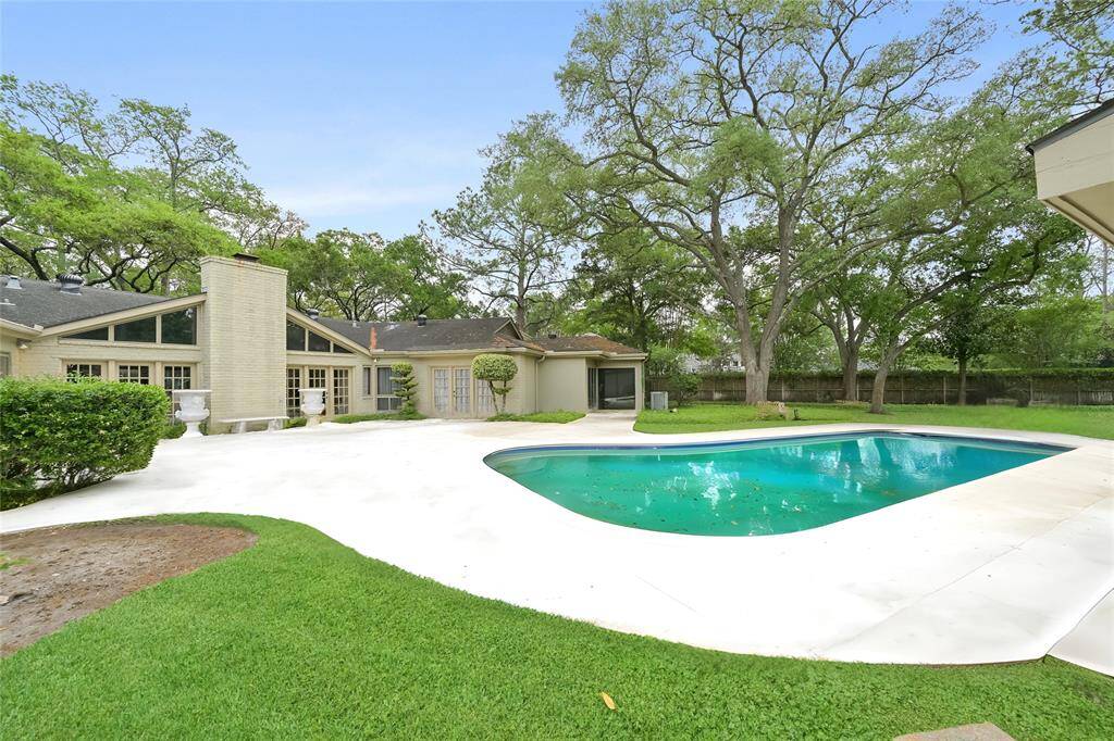 The entertainer’s backyard features a sparkling pool and expansive patio, ideal for gatherings or quiet mornings surrounded by nature.