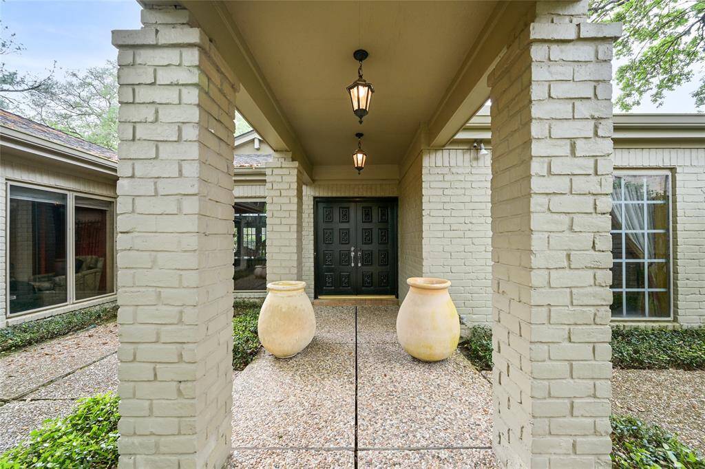 Step through the gated entryway into this welcoming front porch, where classic lantern lighting and oversized pottery create a grand yet inviting first impression.