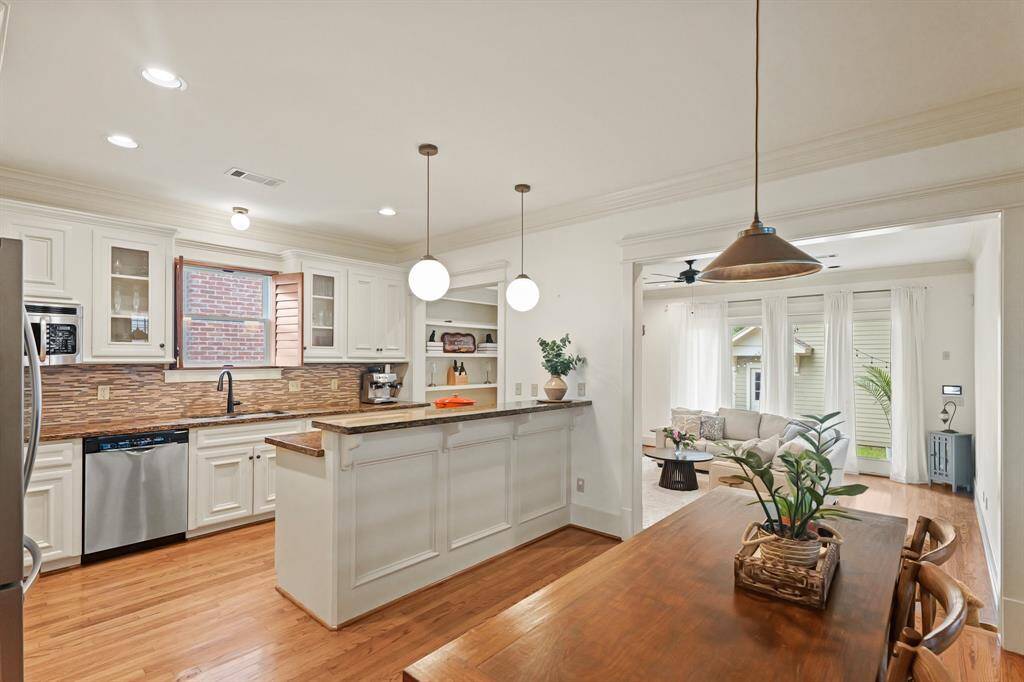 View of the kitchen and breakfast area, overlooking the spacious living room with expansive windows that invite natural light and enhance the open feel of the space