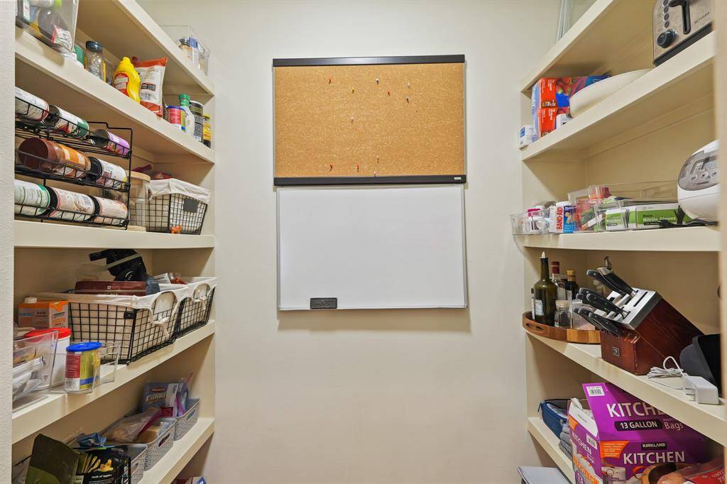 Convenient walk-in pantry offering ample storage space for organization and easy access to kitchen essentials.