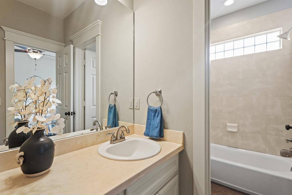 Convenient Jack and Jill bathroom shared between two secondary bedrooms, offering a functional layout with dual vanities and a private feel for each room.