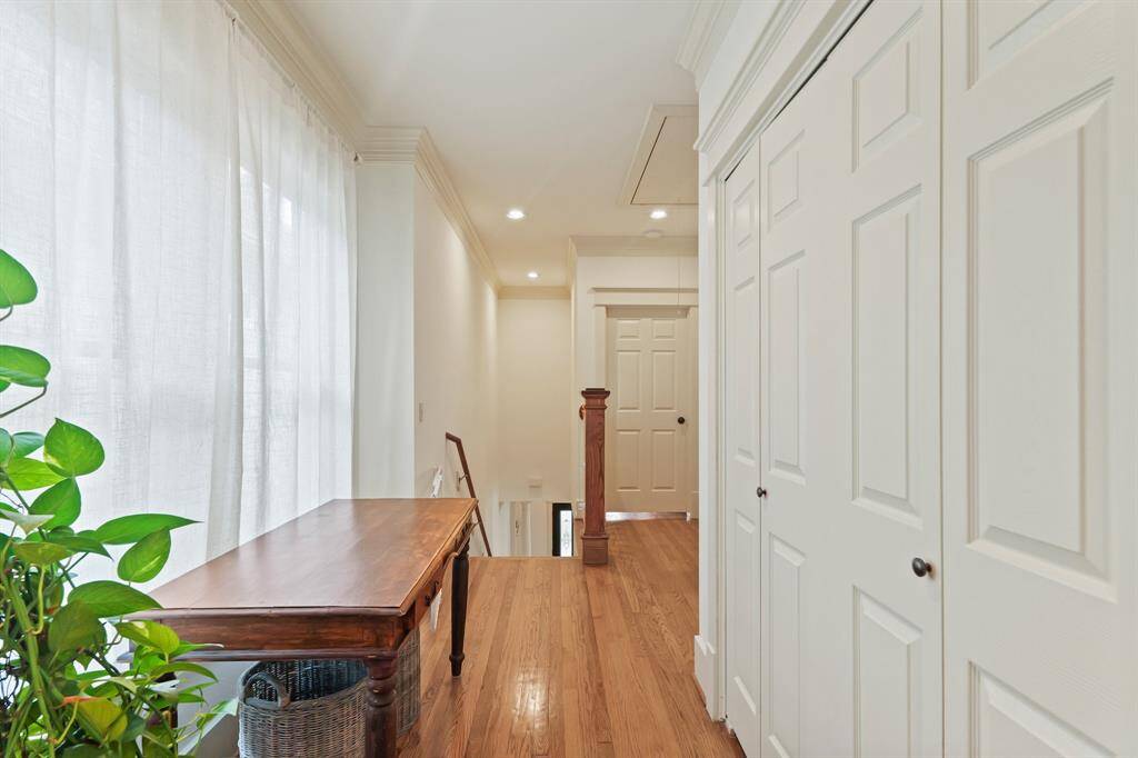 Spacious upstairs hallway with open sightlines, offering a bright and welcoming passage between rooms