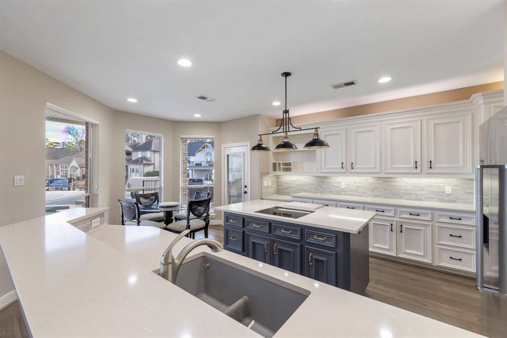 The sophisticated island takes center stage, perfect for meal prep or casual dining. Thoughtfully crafted lighting adds a charming touch, making this kitchen an entertainer's dream.