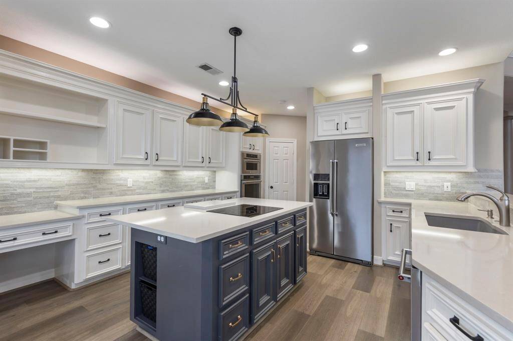Discover culinary perfection in this elegantly designed kitchen featuring stunning quartz countertops, sleek stainless steel appliances, and abundant cabinetry for all your organizational needs.
