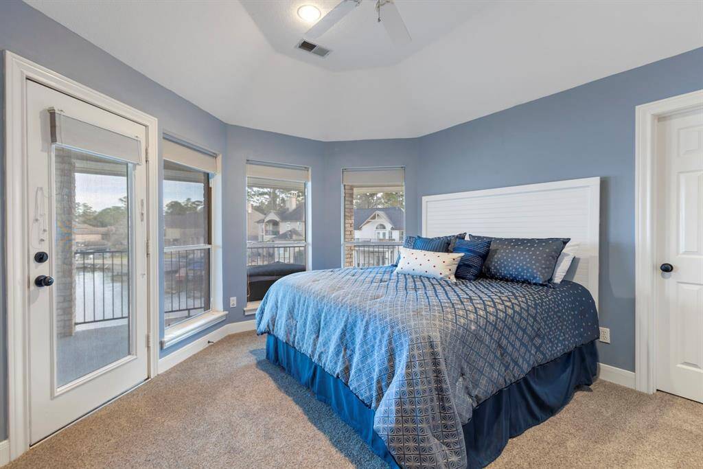 Step into the serene oasis of this stunning secondary bedroom, where expansive windows invite the lakeside views right in.