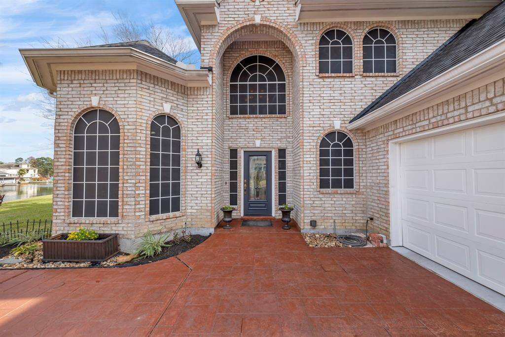 The grand entrance, with its charming arched windows and warm brick exterior, sets the stage for luxurious living.
