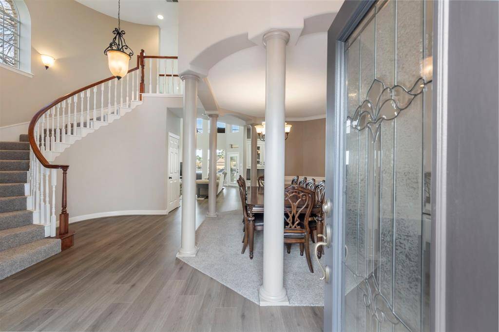 Step into elegance at this magnificent entryway, where a grand spiral staircase spirals your imagination upward, and the open layout offers a glimpse of the spacious living areas beyond.